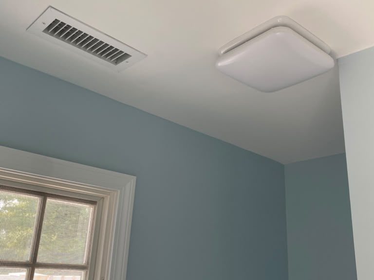 Bathroom with light blue walls, a white ceiling and white window trim