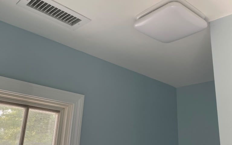 Bathroom with light blue walls, a white ceiling and white window trim