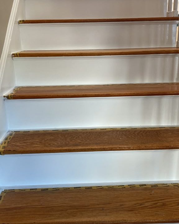 After: Staircase with freshly painted white risers and taped oak treads