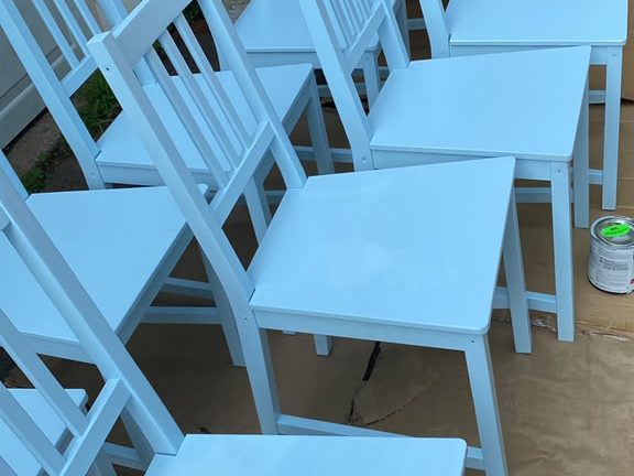 Row of wooden chairs freshly painted light blue