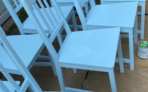 Row of wooden chairs freshly painted light blue