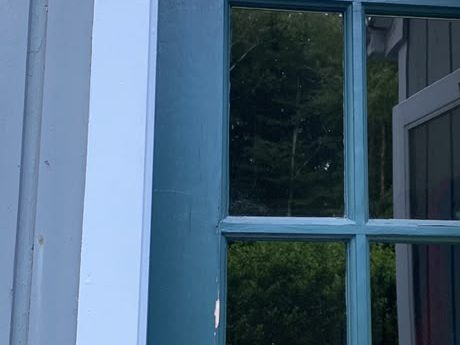 French door painted deep teal inside a freshly painted white casing