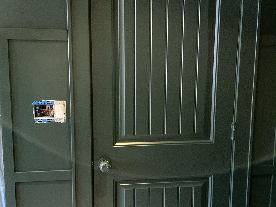 Interior door, casing and wall panels painted dark charcoal, with the floor protected