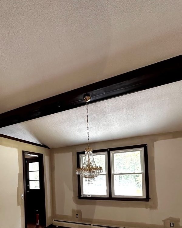 Before: Vaulted room with patched and spackled walls before painting