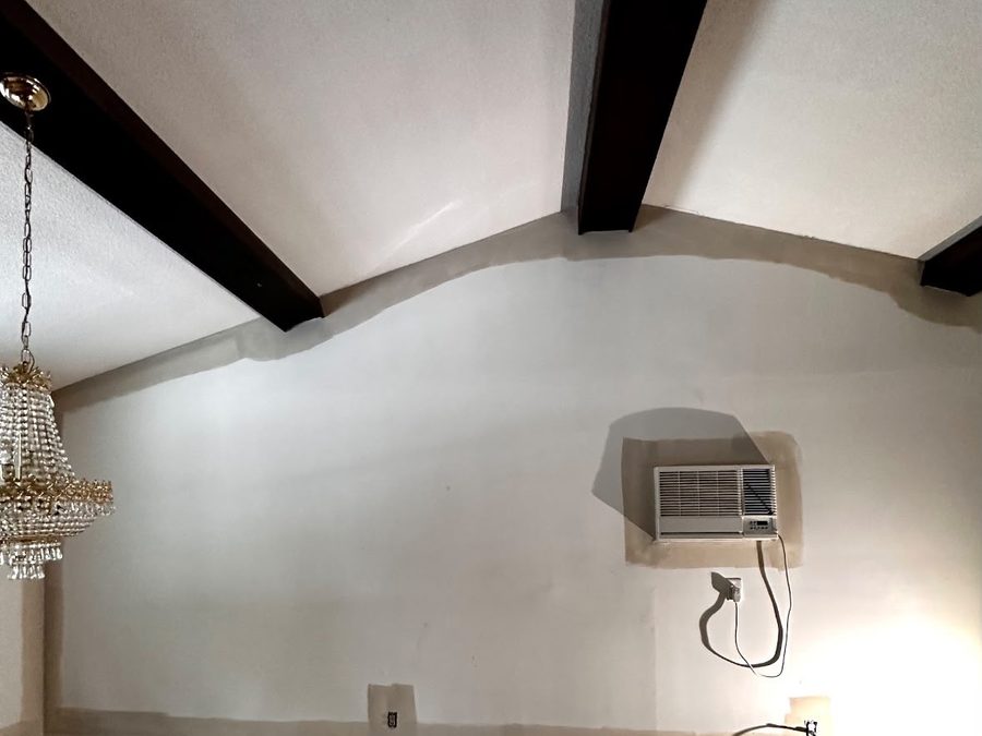 Wall with patched areas around an air conditioner before painting