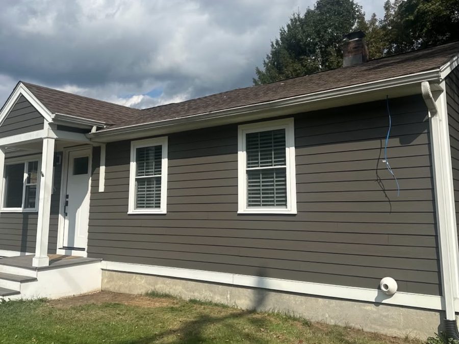 Single-story house with dark gray siding and crisp white trim