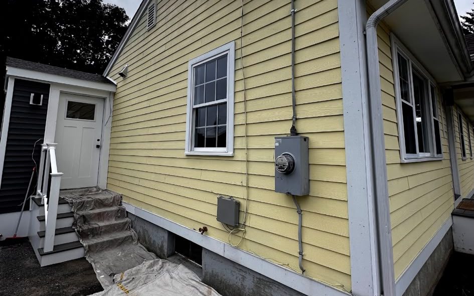 Yellow house with white window trim and corner boards